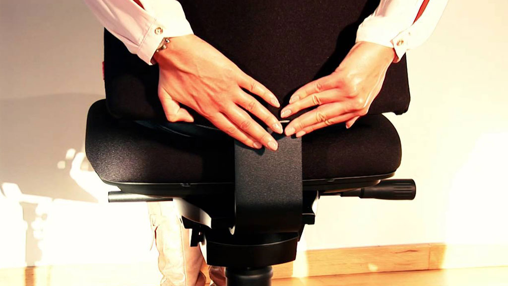 Professionnel testant les réglages d'une chaise ergonomique
